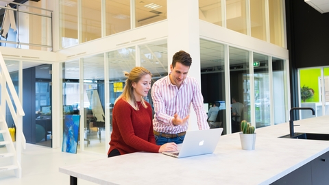 Two employee looking in to laptop