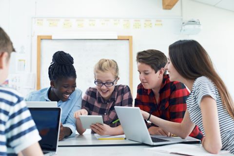 students working together at a table with laptops